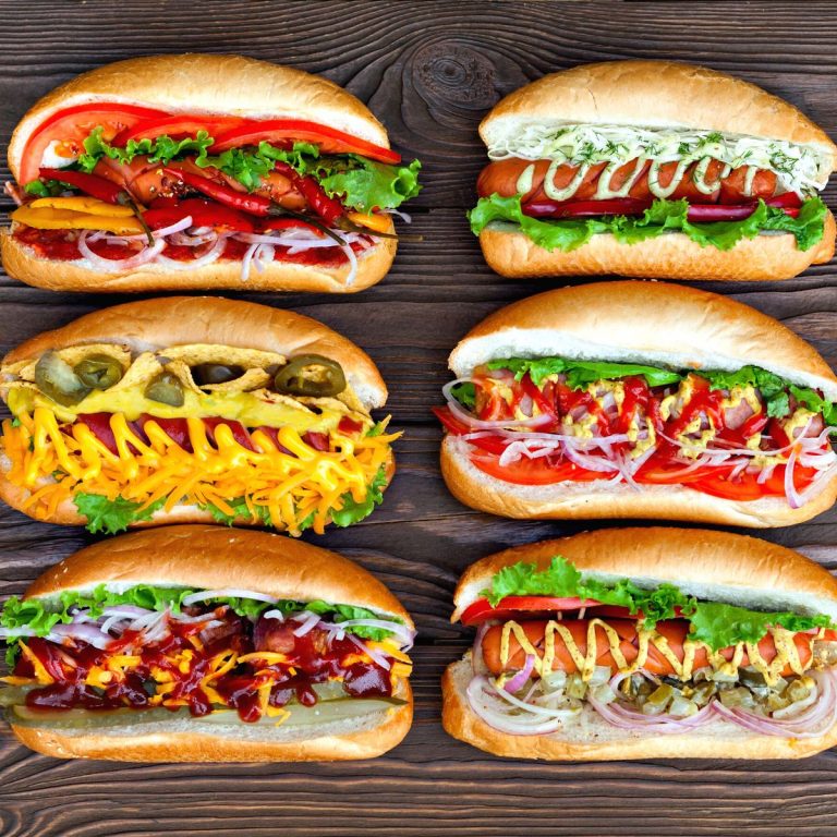 Diverse Hot Dog Rezept Varianten auf einem Holzbrett.